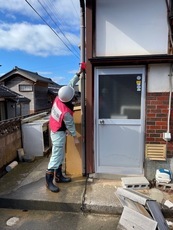 罹災証明書事務支援の写真:東海市の職員が建物の高さを図っている