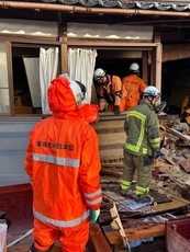 災害支援の写真:東海市の消防士と倒壊した建物